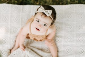 Baby girl looking up at camera during her baby session in Jacksonville Florida.