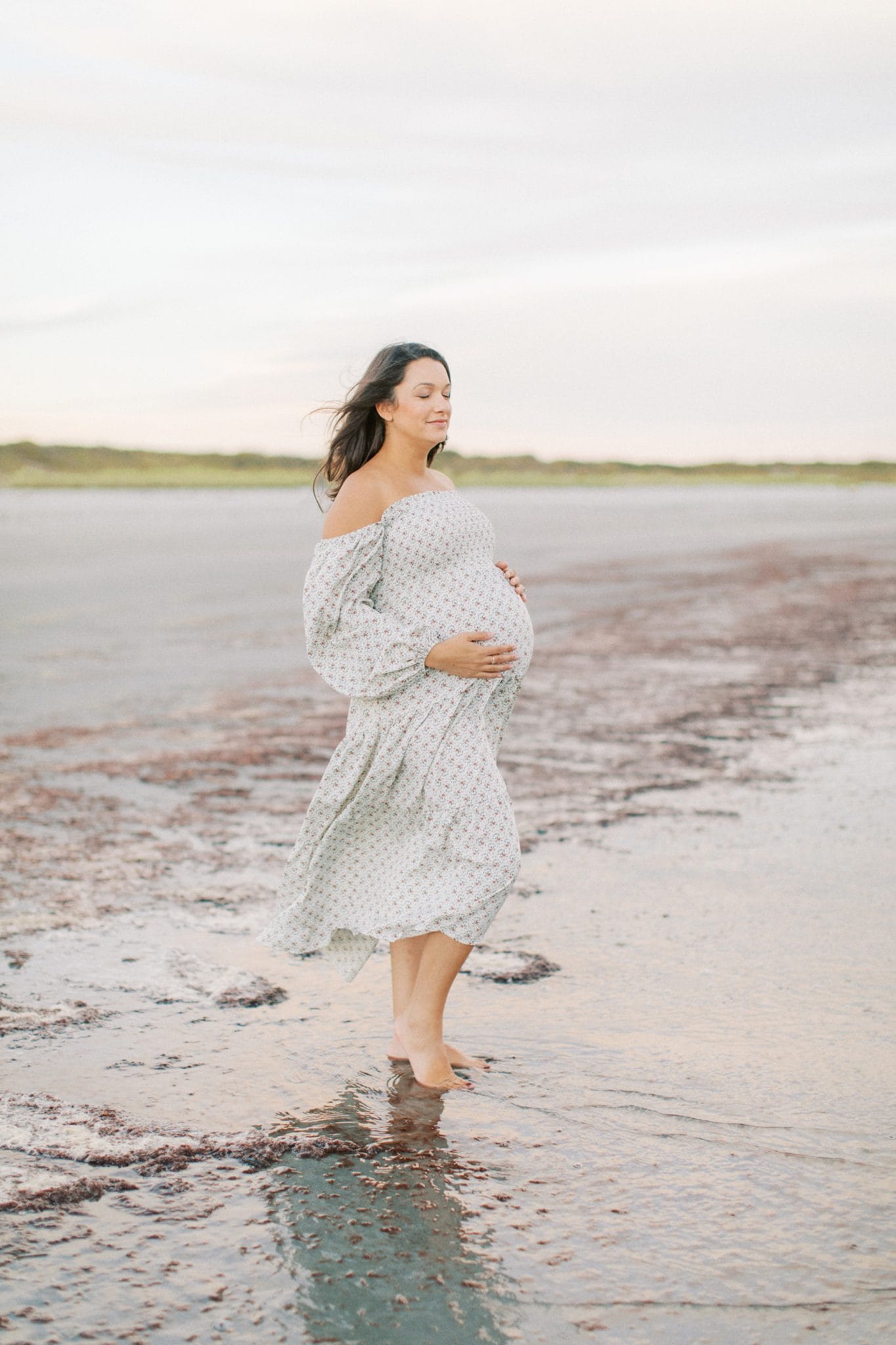 Mother holding pregnant belly while breathing during maternity session in Jacksonville, Fl.