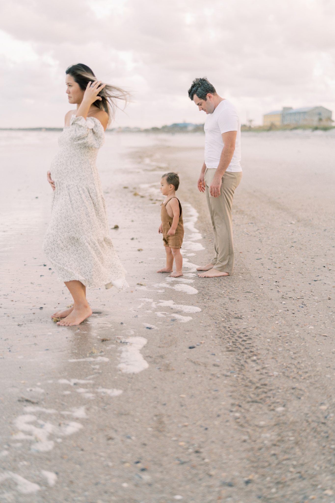 Jacksonville FL Family Photographer- mother holding baby bump while dad is looking at son.