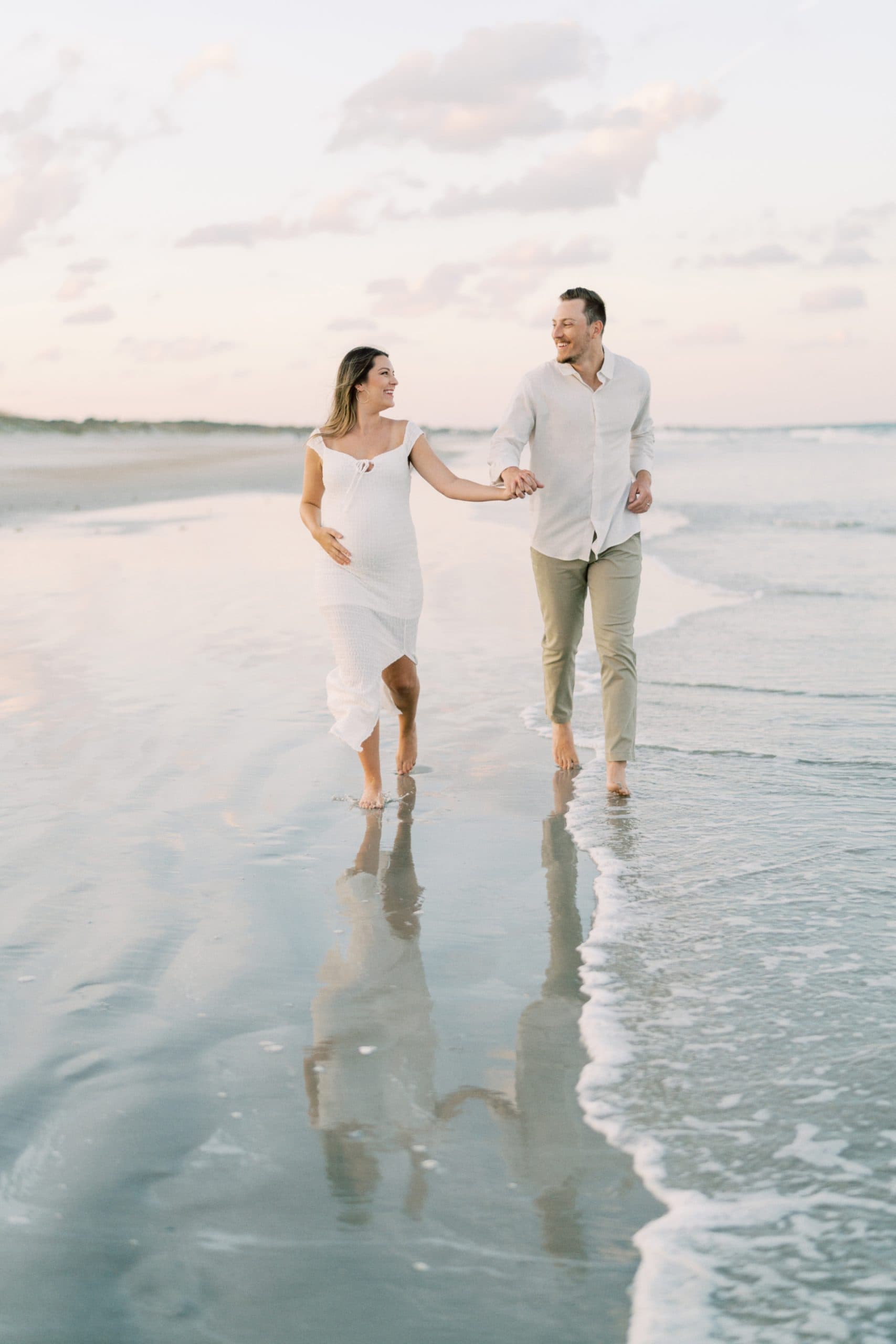 Couple running on water during their Jacksonville Fl maternity photography session.