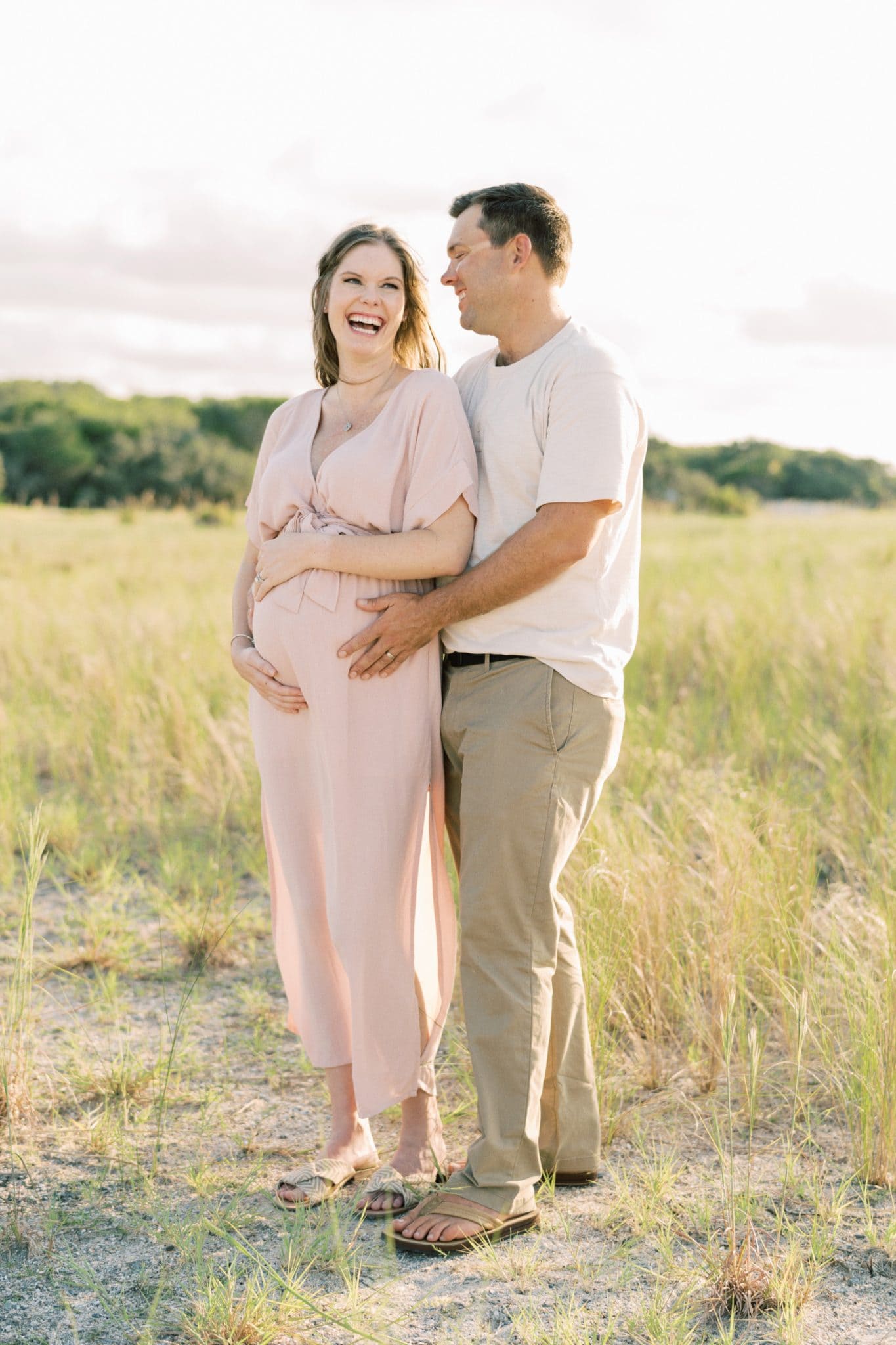 Couple smiling and laughing during their maternity session.
