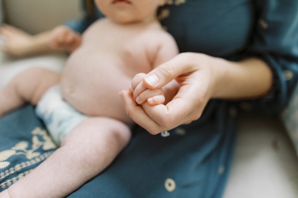 Close Up image of mom holding baby's hand during their newborn session in Jacksonville Fl.