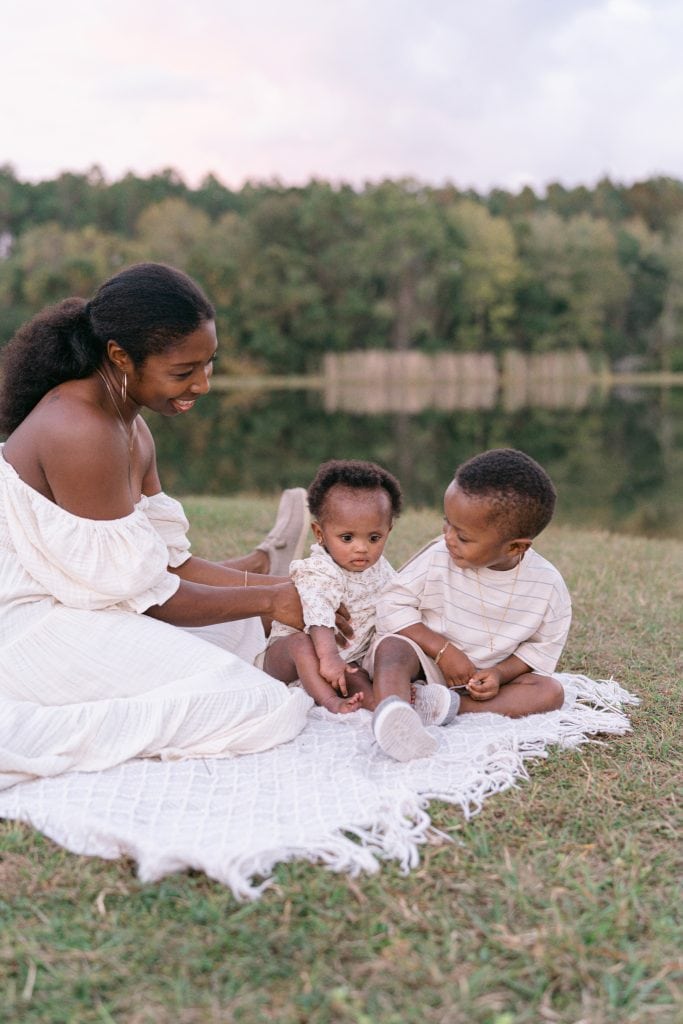 Mothe holding daughter while she leans on her brother.
